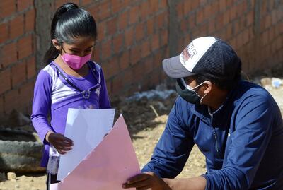 Una alumna del profesor boliviano escucha su explicación.