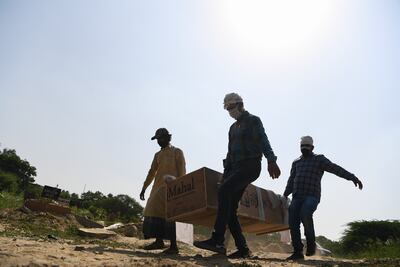 Familiares y trabajadores del cementerio llevan el ataúd de una víctima del COVID-19 en un cementerio en Nueva Delhi el 27 de septiembre de 2020.