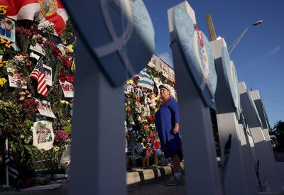 Una mujer visita un monumento memorial a las víctimas del derrumbe del edificio Champlain Towers South, en Surfside.