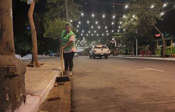 Una funcionaria con vincha festiva, barre la calle Estrella del microcentro.