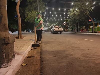 Una funcionaria con vincha festiva, barre la calle Estrella del microcentro.