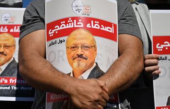 En esta foto de archivo tomada el 2 de octubre de 2020, amigos del periodista saudí asesinado Jamal Khashoggi sostienen carteles con su foto mientras asisten a un evento que marca el segundo aniversario de su asesinato frente al Consulado de Arabia Saudita en Estambul.