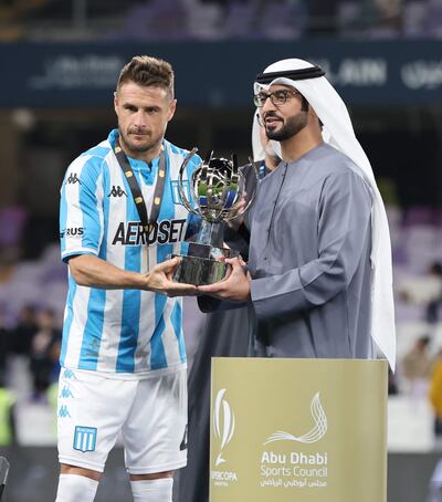 Ivan Pillud (L), capitán de Racing Club, recibe el trofeo de manos del Jeque Sultan bin Hamdan bin Zayed Al Nahyan, Vicepresidente del Club Deportivo y Cultural de Al Ain, Presidente del Executive Club, y presidente del Talents Care Committee tras ganar la final de fútbol de la Supercopa Argentina entre Boca Juniors y Racing Club en Al Ain, Emiratos Árabes Unidos, el 20 de enero de 2023. (Emiratos Árabes Unidos)
