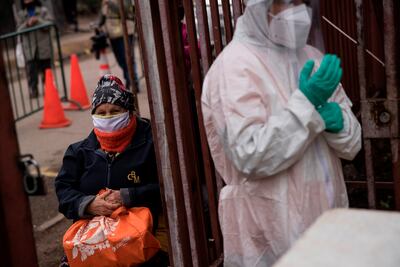 Vecinos de la comuna de Renca en Santiago, Chile, esperan en fila para recibir una ración de comida en una olla común.