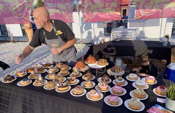 Un empleado de la dulcería Pink Love Donut ofrece una amplia variedad de rosquillas en Smorgasburg Miami.