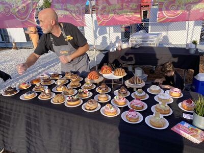 Un empleado de la dulcería Pink Love Donut ofrece una amplia variedad de rosquillas en Smorgasburg Miami.