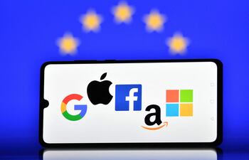 (FILES) This file illustration picture taken in London on December 18, 2020 shows the logos of Google, Apple, Facebook, Amazon and Microsoft displayed on a mobile phone with an EU flag displayed in the background. - A European Union court on November 10, 2021, rejected a Google appeal against a 2.4-billion euro ($2.8-billion) anti-trust fine. US tech giants Google, Apple, Facebook, Amazon and Microsoft have been accused of not paying enough taxes, stifling competition, stealing media content and threatening democracy by spreading fake news. (Photo by JUSTIN TALLIS / AFP)