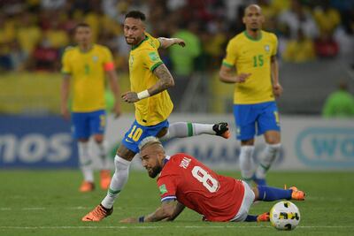 El chileno Arturo Vidal queda en el suelo, mientras el brasileño Neymar se apresta para seguir con la jugada.