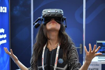 Una joven utiliza el visor y chaleco de realidad virtual de Actronika, en un evento en París.