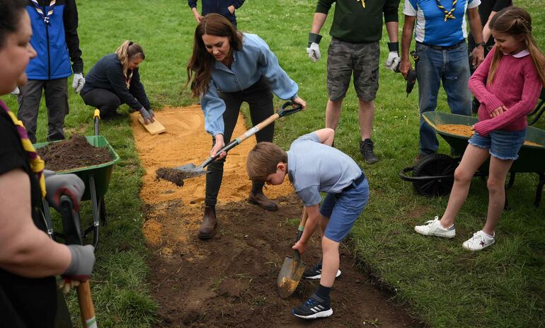 Catalina (Kaye), princesa de Gales y sus hijos ayudan a plantar pasto.