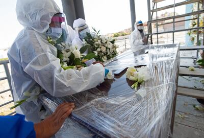 Una mujer llora junto al ataúd de su esposo, fallecido por complicaciones del COVID-19, en el cementerio de La Apacheta en la ciudad andina de Arequipa, en el sur de Perú.