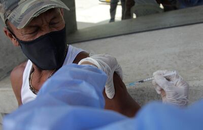 Adulto mayor de Colombia recibe la dosis antiCOVID.