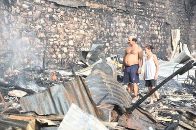Dos personas observan lo que queda de su vivienda tras el siniestro.