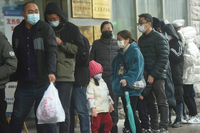 Varias personas hacen fila para realizarse pruebas de covid-19 fuera de un hospital en Hangzhou, en la provincia china de Zhejiang, este viernes.