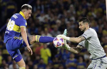 Luis Vázquez (i), delantero de Boca Juniors, procura puntear el balón ante la salida del Gabriel Arias, arquero chileno de Racing Club.