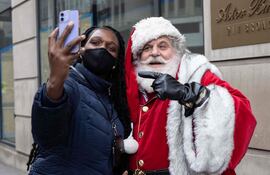 Una transeúnte se toma una selfie con el Papá Noel de The New York .