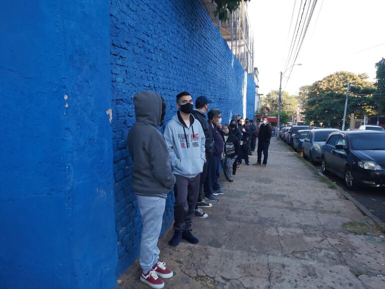 Adultos formando fila frente a Salesianito ya antes de la apertura del Polideportivo. 