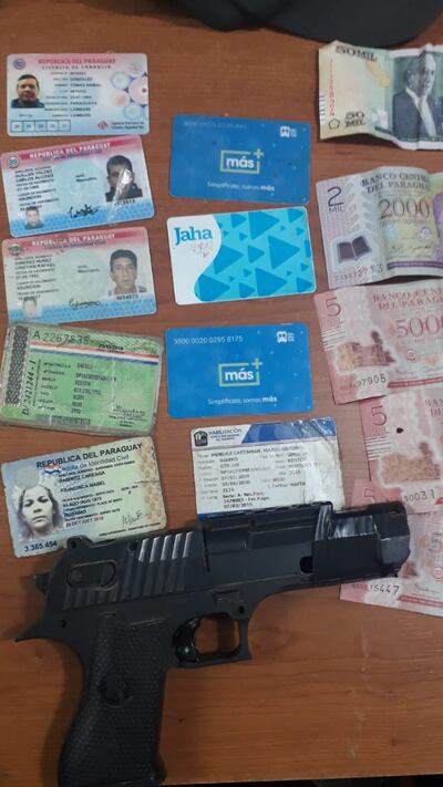 Arma de fuego y documentos encontrados en poder de los detenidos.