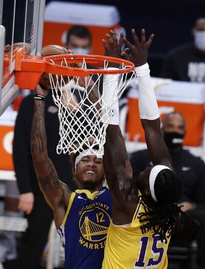 Kelly Oubre Jr. (I) de Golden State trata de imponerse en lo alto a Montrezl Harrell de Los Lakers.