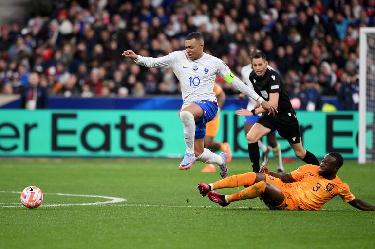 France's forward Kylian Mbappe (L) fights for the ball with Netherlands' defender Lutsharel Geertruida (R) during the UEFA Euro 2024 qualification football match between France and Netherlands at the Stade de France in Saint-Denis, north of Paris, on March 24, 2023. (Photo by FRANCK FIFE / AFP)