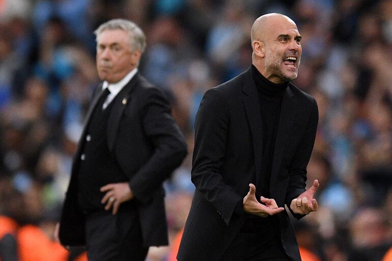 El entrenador español del Manchester City, Pep Guardiola (derecha), observado por el entrenador italiano del Real Madrid, Carlo Ancelotti, celebra el gol de apertura durante el partido de vuelta de la semifinal de la Liga de Campeones de la UEFA entre el Manchester City y el Real Madrid en el estadio Etihad de Manchester, al noroeste Inglaterra, el 17 de mayo de 2023.
