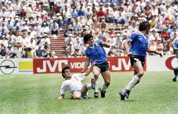 Diego Maradona (c) superando la marca del defensor inglés Steve Hodge, con quien intercambió su camiseta al final del partido.