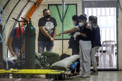 Médicos voluntarios miembros de la organización Ángeles contra el Covid ayudan al paciente COVID-19 en su hospital de carpas en Santa Cruz, Bolivia.