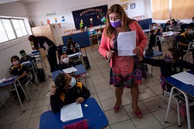 Una docente es vista con un grupo de alumnos durante una clase en el Colegio Polivalente Patricio Mekis durante la primera jornada de inicio del curso escolar 2021, en Santiago (Chile).