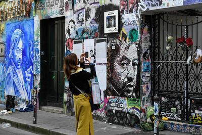 Una mujer toma una fotografía de la puerta de entrada de la casa del difunto músico, compositor y cantante francés Serge Gainsbourg en el centro de París, treinta años después de su muerte.