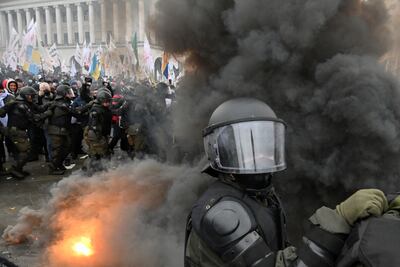 Policías antidisturbios y manifestantes que se oponen al confinamiento debido a la pandemia de covid-19 se enfrentan en Kiev, este martes.