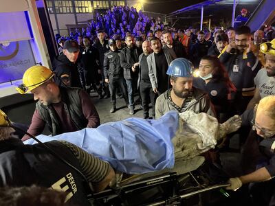 Paramédicos y mineros llevan a un minero herido a una ambulancia en el lugar de la explosión después de que ocurriera una explosión en una mina de carbón en Bartin, Turquía, el 14 de octubre de 2022.
