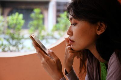 Una mujer manipula su teléfono celular.