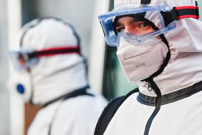 Workers dressed with protective suits stand in front of a future temporary COVID-19 vaccination unit in Sofia, on December 15, 2020. (Photo by NIKOLAY DOYCHINOV / AFP)