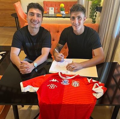 Juan Ignacio Saborido estampa su firma en compañía del gerente deportivo del club.