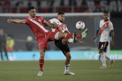 El paraguayo Gabriel Ávalos (i), de Argentinos Juniors, disputa el balón con el chileno Paulo Díaz, de River Plate, durante un reciente partido por la Liga argentina.