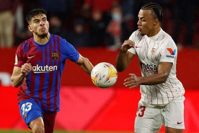 Jules Koundé (d), quien fue expulsado por tirar la pelota a la cara a Jordi Alba, disputa el balón con Abdessamad Ezzalzouli.