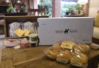 Bodoque Montoya entrega una caja, con las hamburguesas para ser cocinadas y preparadas en la casa, con todos los ingredientes.