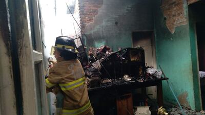 La bombero Andrea Caballero durante las tareas de extinción de las llamas dentro de la vivienda de la pareja de docentes que había viajado a Asunción para pedir aumento salarial.