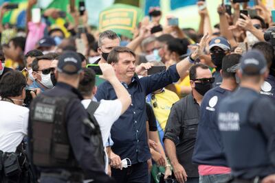 El presidente de Brasil, Jair Bolsonaro, se reúne con simpatizantes este domingo, en Brasilia (Brasil). Cientos de SUS seguidores se aglomeraron cerca del palacio de Gobierno para alabar a su ídolo, que sin protección se mezcló entre la multitud, ignorando de nuevo las recomendaciones por el COVID-19.