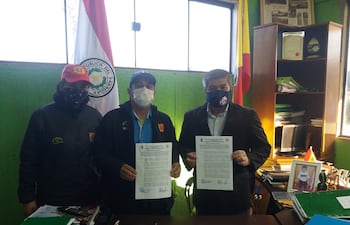 El intendente Mario Noguera (d) posa junto a representantes del cuartel de bomberos, exhibiendo la resolución que autoriza el uso de un predio por diez años.