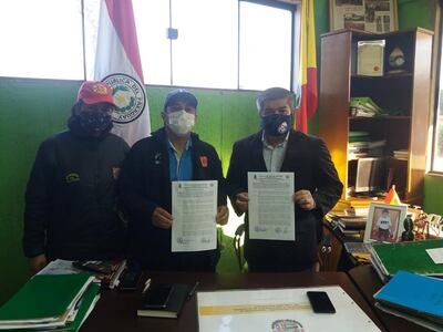 El intendente Mario Noguera (d) posa junto a representantes del cuartel de bomberos, exhibiendo la resolución que autoriza el uso de un predio por diez años.