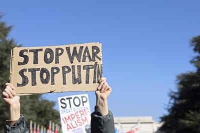 Un manifestante sostiene un cartel que dice "Stop War Stop Putin" mientras protesta contra la operación militar masiva de Rusia contra Ucrania durante una manifestación en la sede de las Naciones Unidas en Ginebra.