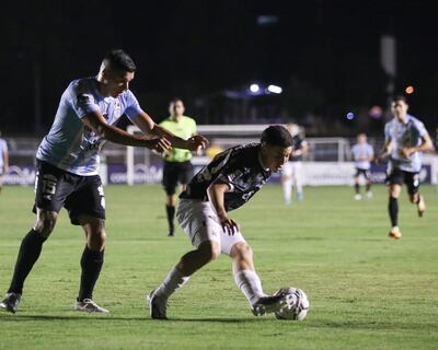 Iván Villalba de Guaireña, disputa el balón con Enso González de Libertad, en el Parque del Guairá.