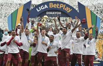 El paraguayo Gustavo Ramírez (la cabeza casi pegada al trofeo), ayer en el festejo del Tolima.