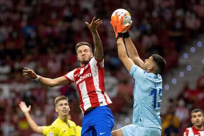 El portero del Villarreal Gerónimo Rulli (d) salta con Saúl Ñíguez, del Atlético de Madrid, durante el partido de la tercera jornada de LaLiga que Atlético de Madrid y Villarreal CF disputan hoy domingo en el Wanda Metropolitano.
