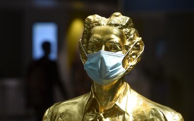 Una estatua dorada que representa al ex rey bávaro Ludwig II está decorada con una máscara facial protectora en una sala terminal del aeropuerto "Franz-Josef-Strauss" en Munich, sur de Alemania.