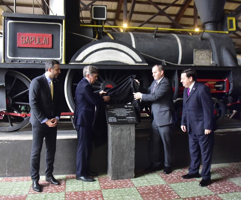El ministro britanico, David Rutley (2do. de la Izq.) descubre una placa conmemorativa junto al canciller de Paraguay, Julio Arriola (2do de la Der.). Los acompañan el embajador Ramin Navai (1ro. de la izq.) y el director de FEPASA, Lauro Ramírez. 