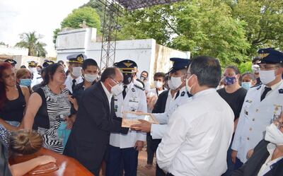 El Tte. Pablo Vera hace entrega de la bandera en un estuche de madera y vidrio a Óscar Sotelo, papá del militar fallecido.
