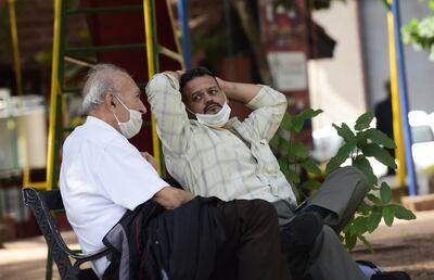 Dos personas conversan. En ambos casos el uso del tapabocas no es adecuado, ya que no cubre nariz y boca.