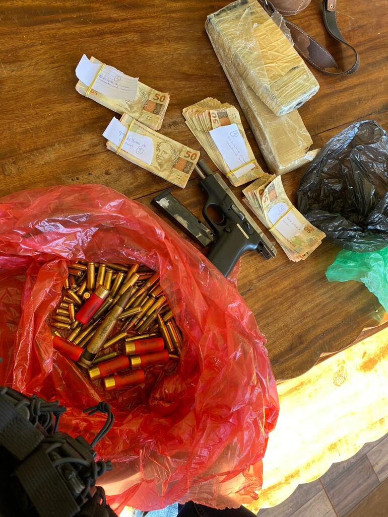 La pistola, las municiones y el dinero hallado durante la revisión del inmueble.